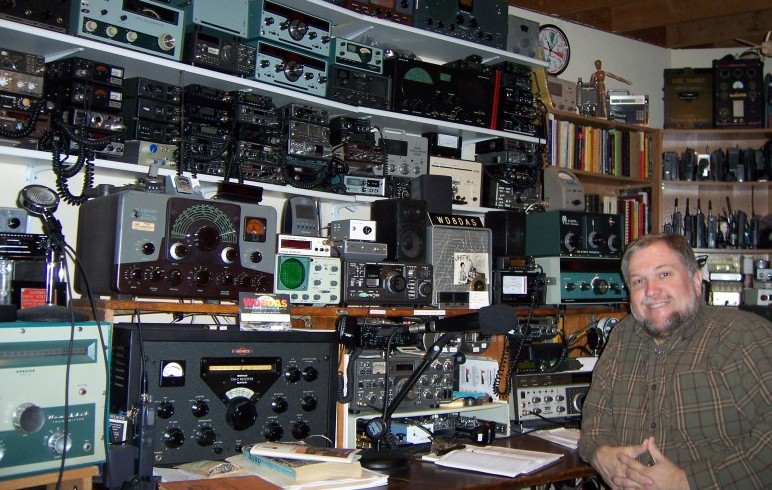 Steve's operating position. He has on his desk Heathkit Apache, Collins 75A4, Kenwood transceiver TenTec transceiver, keyer and more. Then there are 4 levels of shelving built in back of the dexk containing all sorts of VHF transceivers, Johnson Ranger monitor scope and it goes around the side to even more stuff. My comment, Holy Crap!!!